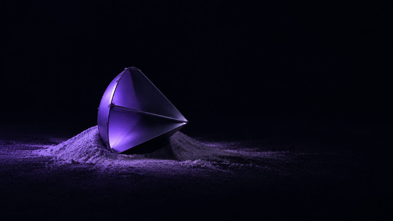 A conical radar reflector on a drift of fine dust under violet light